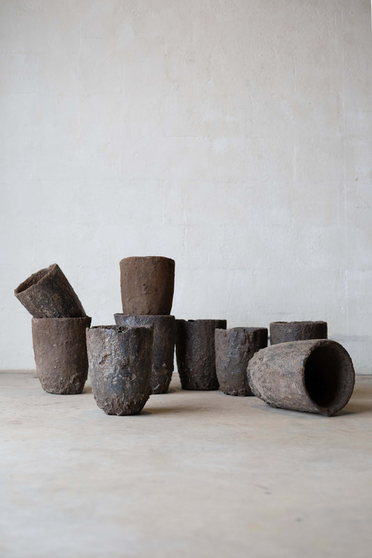 A variety of industrial foundry crucibles on a concrete floor.