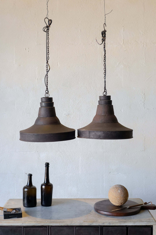 Pair of pendant lights in industrial style, featuring natural patina, hanging over a small desk.