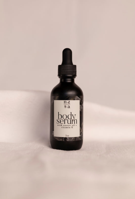 Black bottle of anti-aging body serum with a dropper on a beige background.