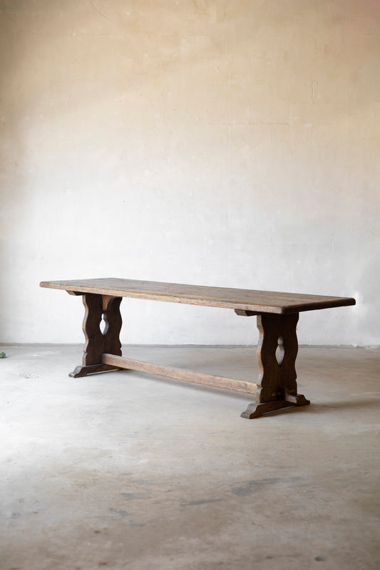 Wooden table with rustic design on a plain floor and wall background