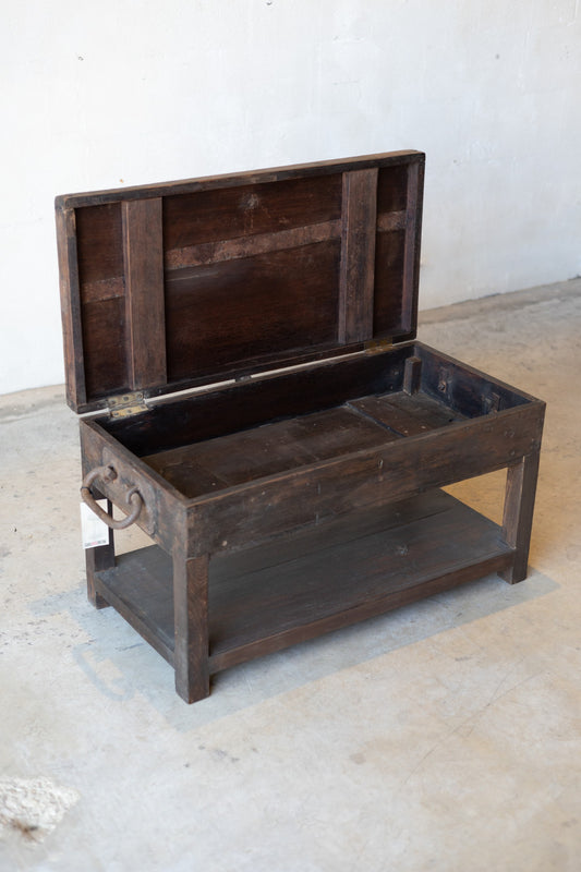 British colonial teak coffee table with iron handles and opening table-top for storage.