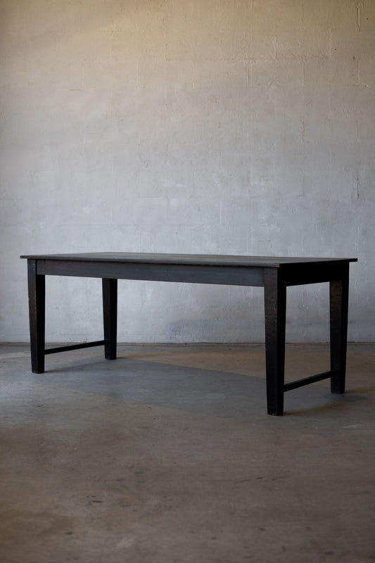 Black wooden table against a plain gray wall