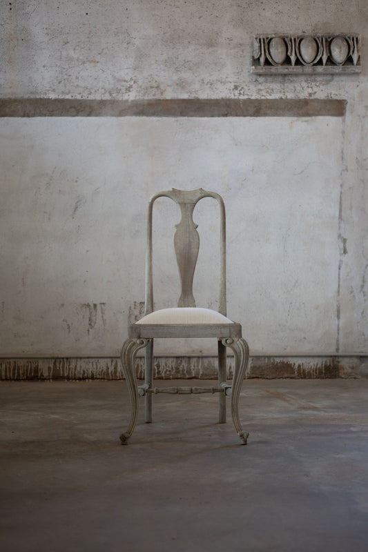 Vintage chair in a room with textured walls and concrete floor