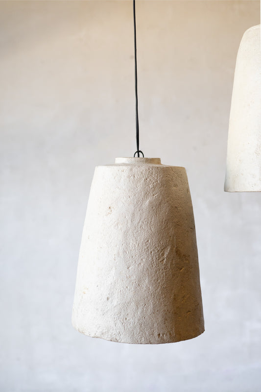 Textured pendant light hanging against a plain background.
