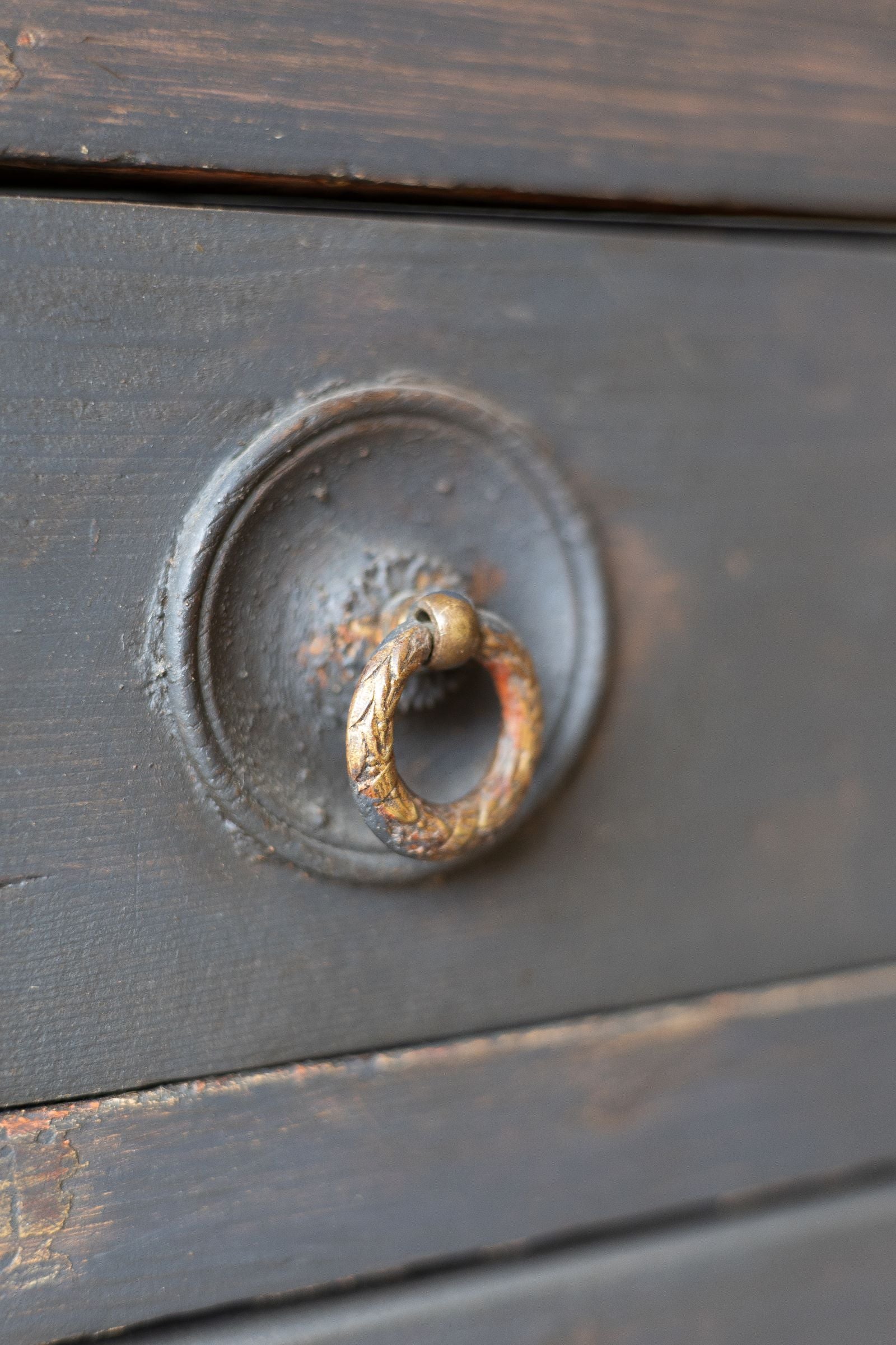 Drawer handle of dark wooden sideboard.