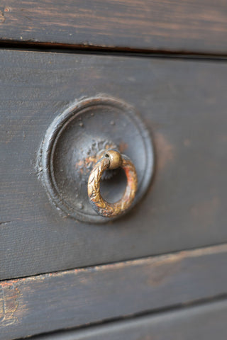 Drawer handle of dark wooden sideboard.