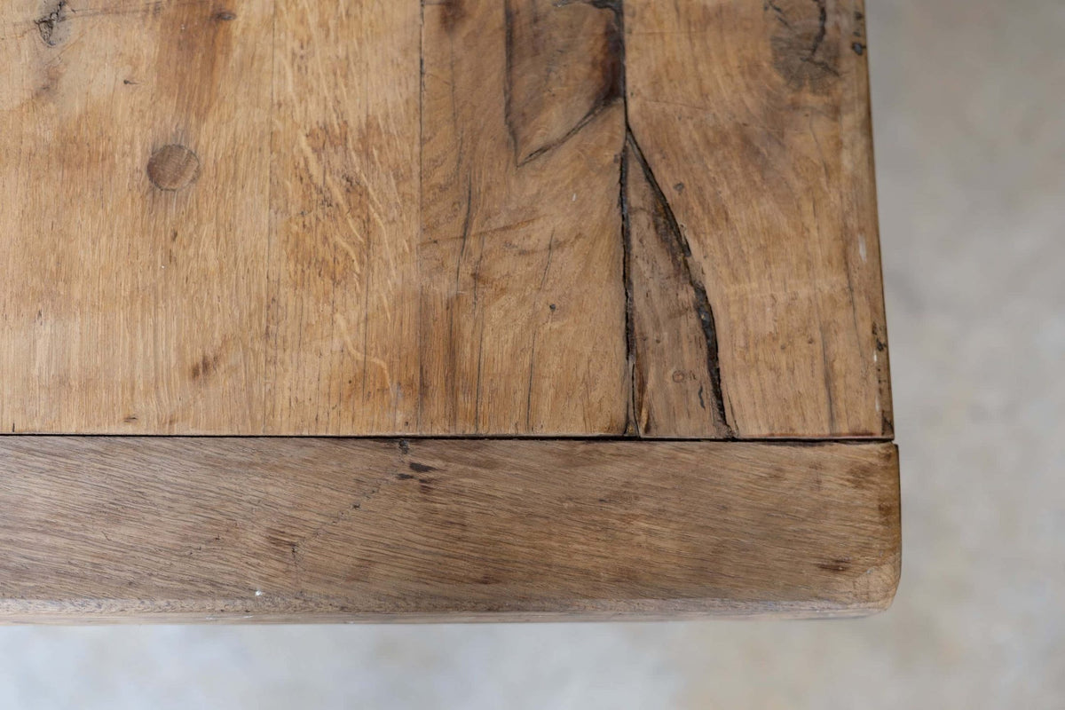 Close-up of wooden dining table's natural grain and warm, rustic tone.