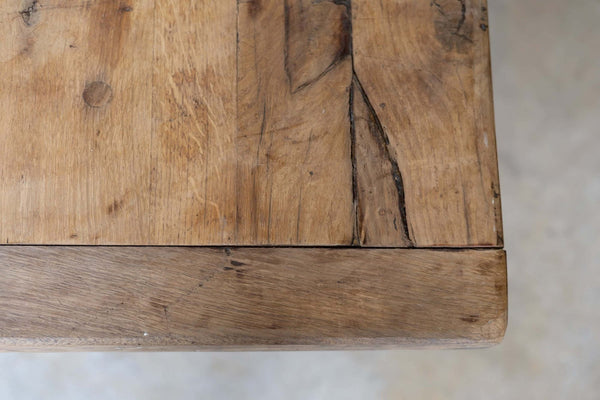 Close-up of wooden dining table's natural grain and warm, rustic tone.