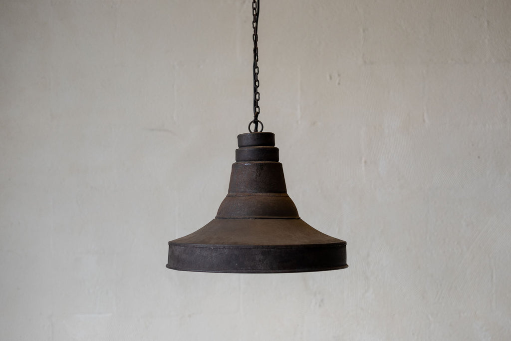 Wide image of antique industrial pendant light against white background. 