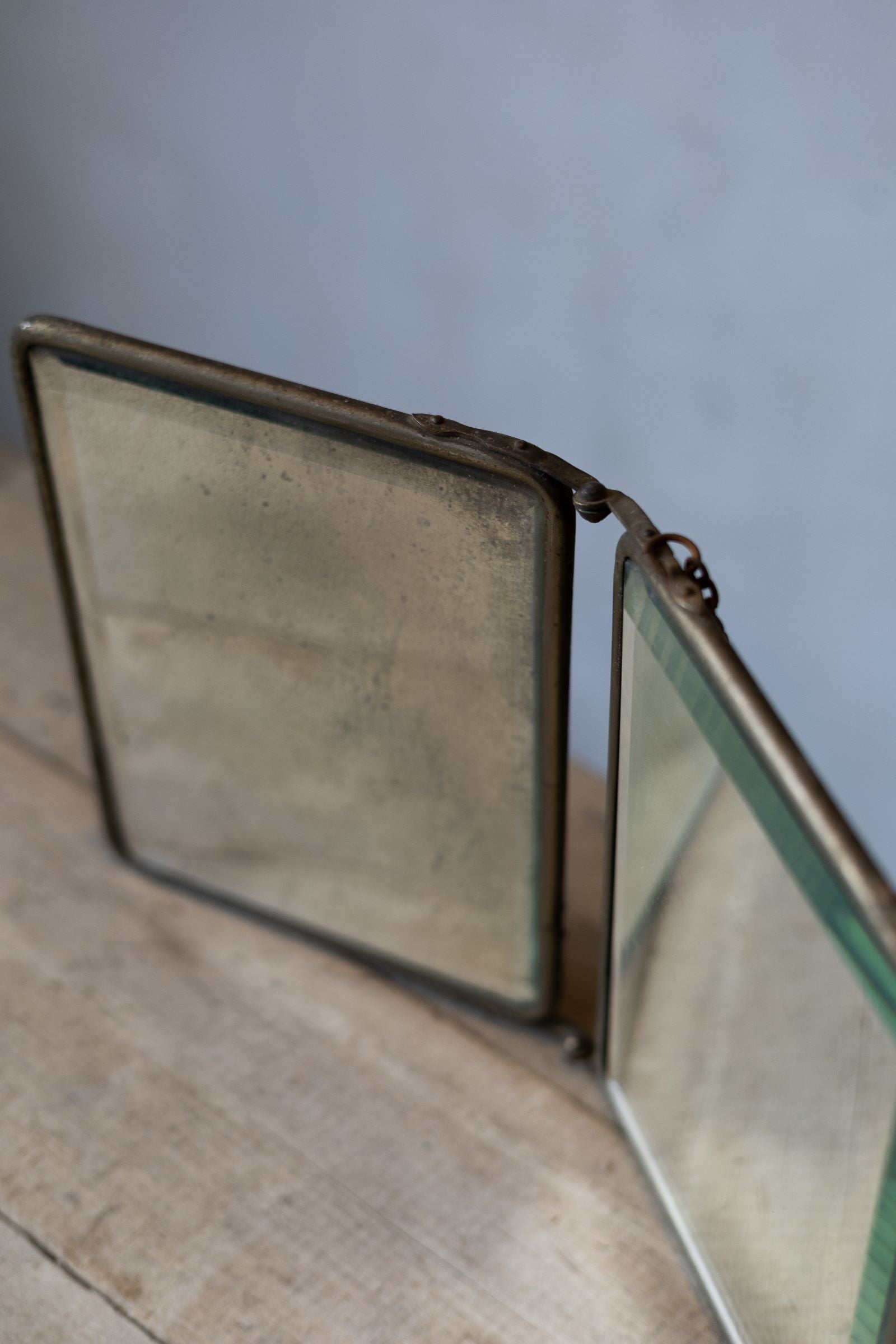 Vintage compact mirror with brass frame on a wooden surface