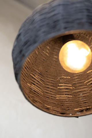 Offset picture of the inside of the black woven beehive pendant with warm light. 