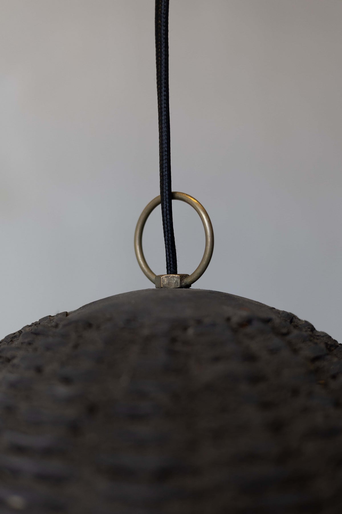 Close up of the top of the black woven beehive pendant with black woven wire and brass loop. 
