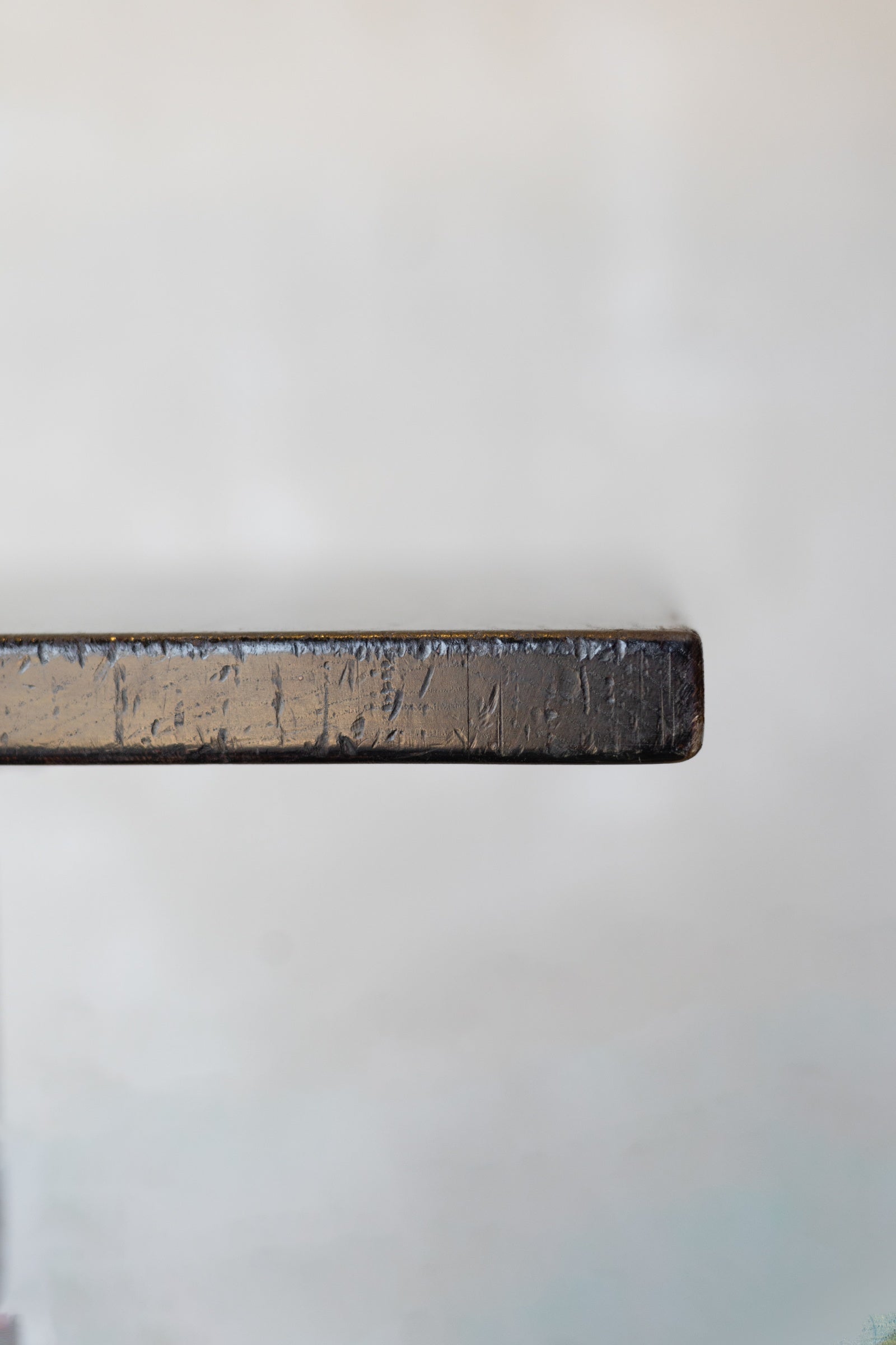 Close-up of edge of dark wood table on a white background.