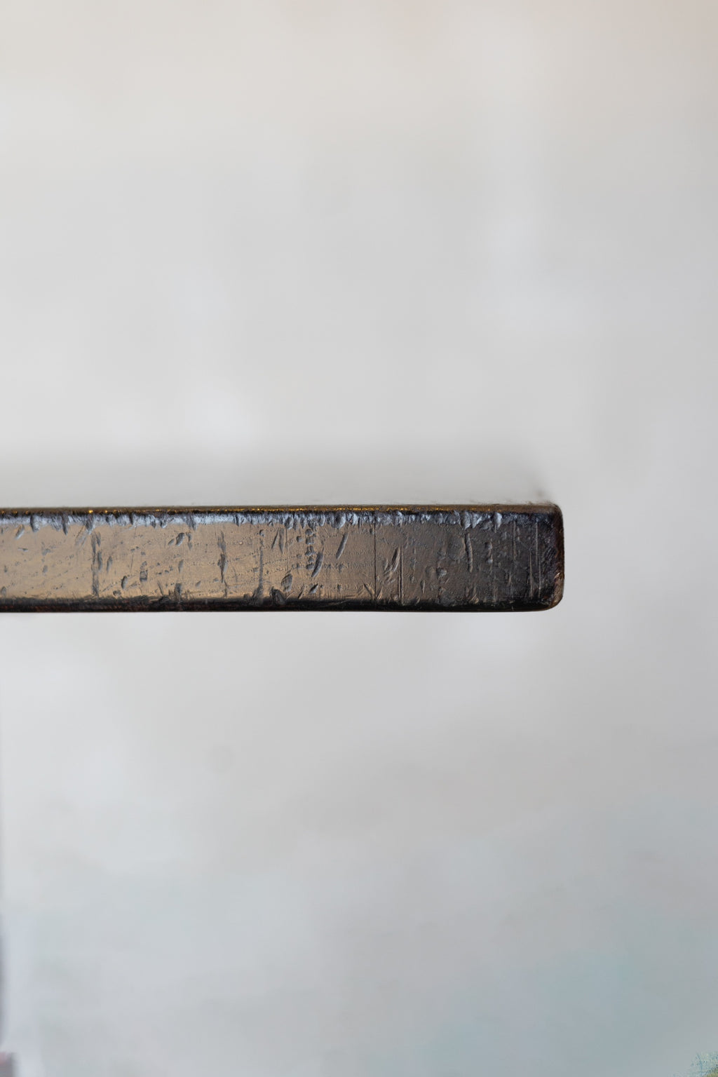 Close-up of edge of dark wood table on a white background.