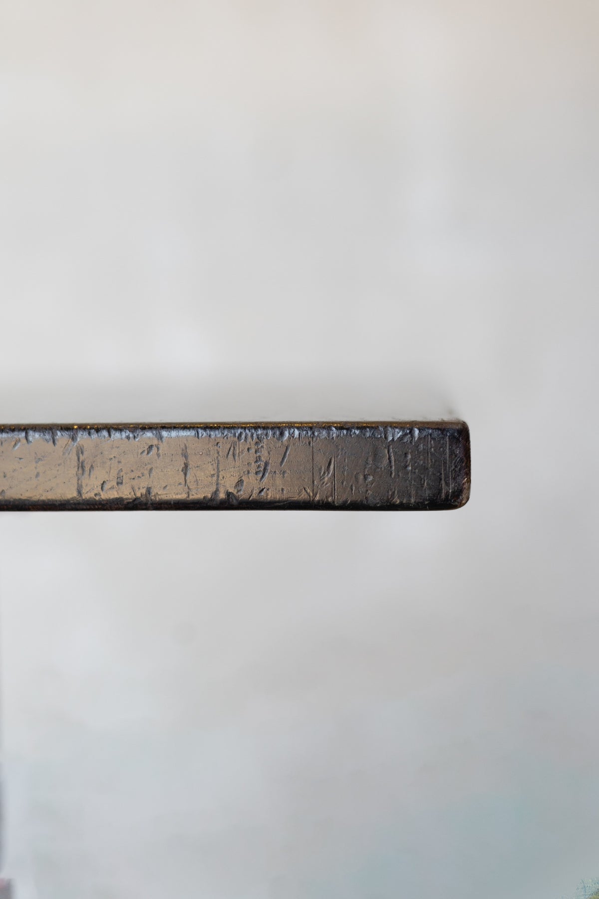Close-up of edge of dark wood table on a white background.
