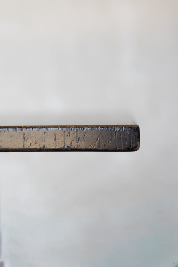 Close-up of edge of dark wood table on a white background.