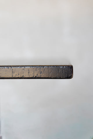 Close-up of edge of dark wood table on a white background.