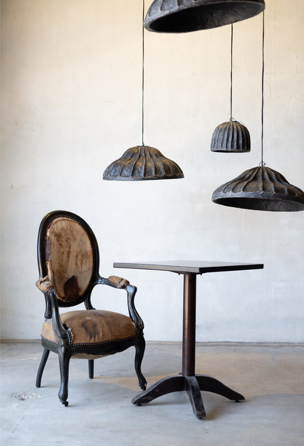Vintage chair and table with rustic-style pendant lights in a minimalistic setting.
