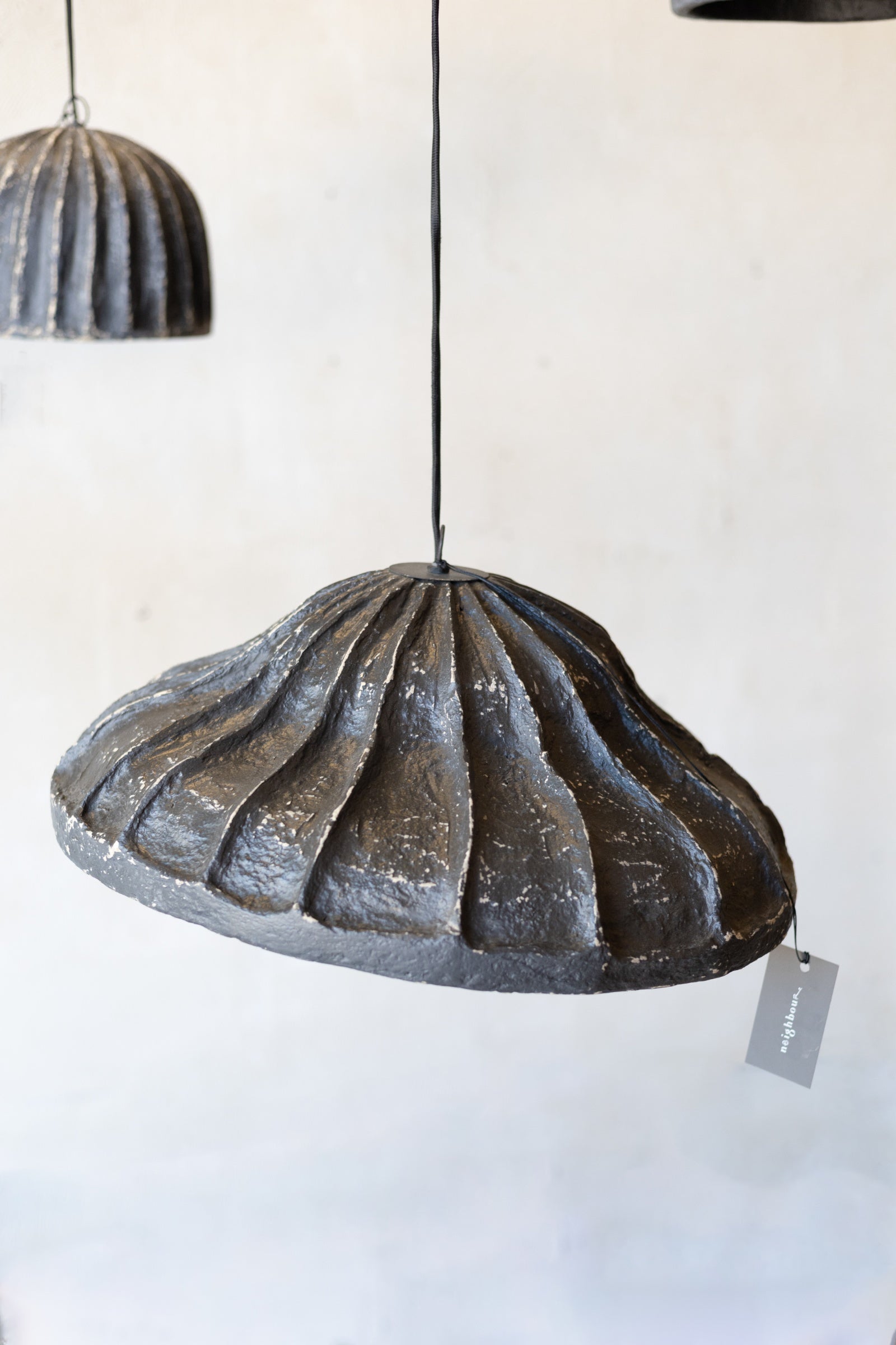 Decorative pendant light with ribbed design on a white background.