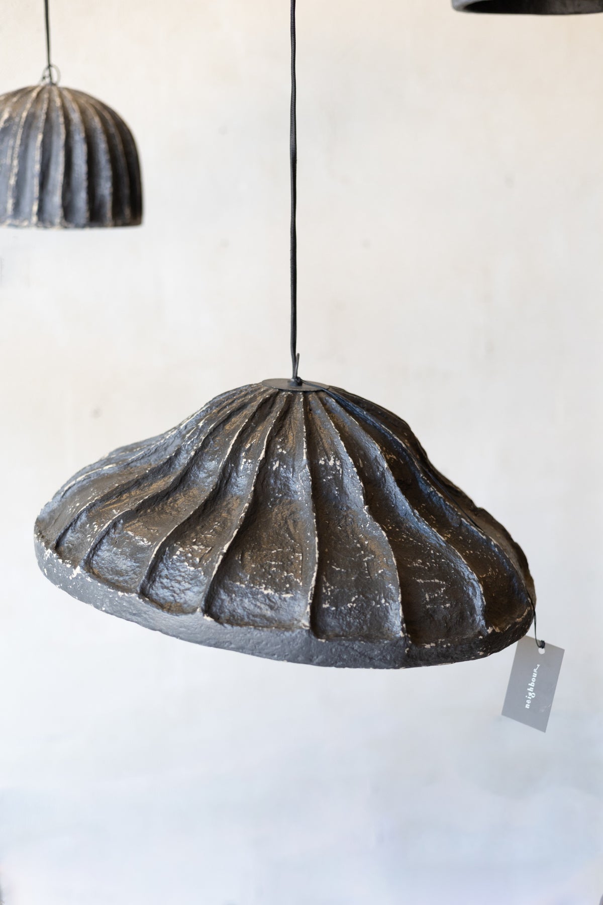 Decorative pendant light with ribbed design on a white background.