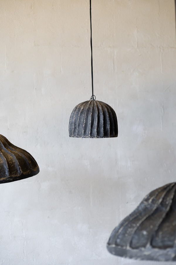 Three rustic pendant lights hanging against a textured wall.