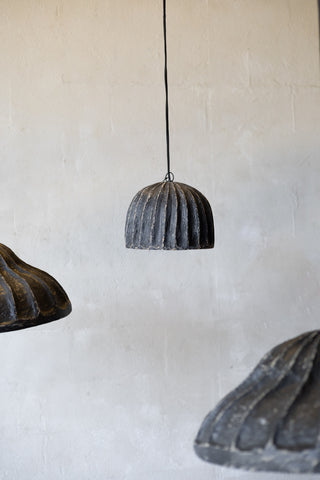 Three rustic pendant lights hanging against a textured wall.