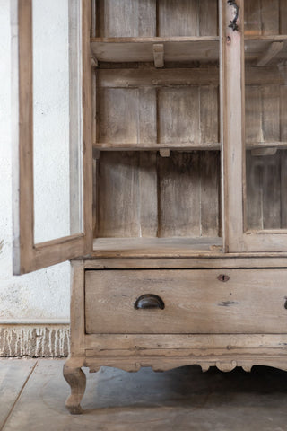 Wooden cabinet with glass doors and a drawer on a neutral background
