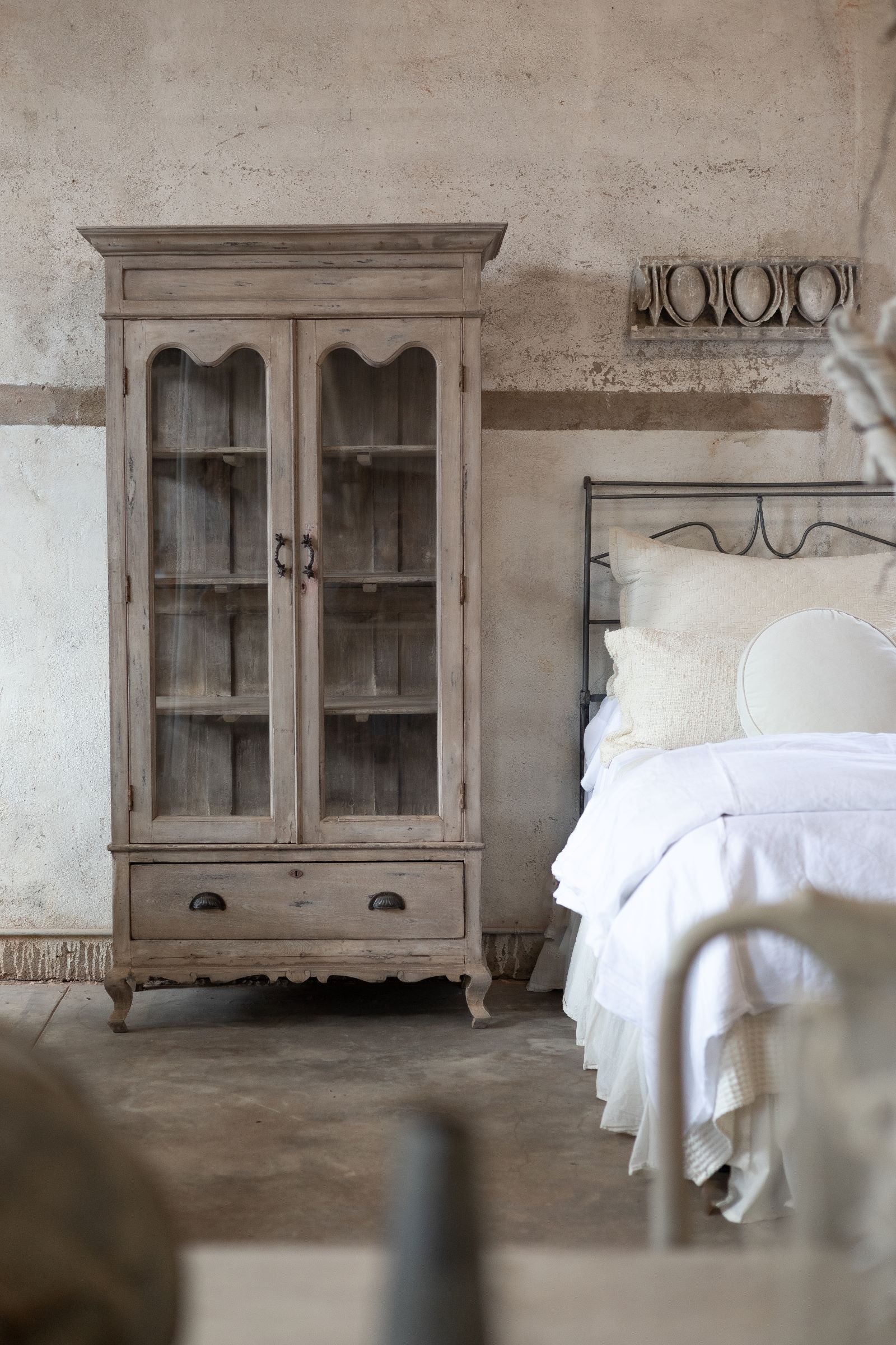 Vintage-style bedroom with wooden cabinet and bed.