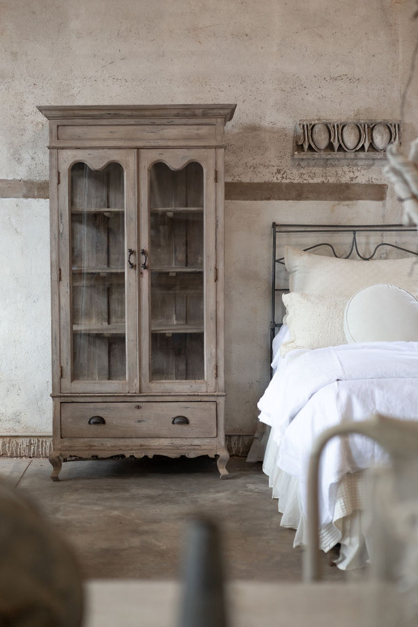 Vintage-style bedroom with wooden cabinet and bed.