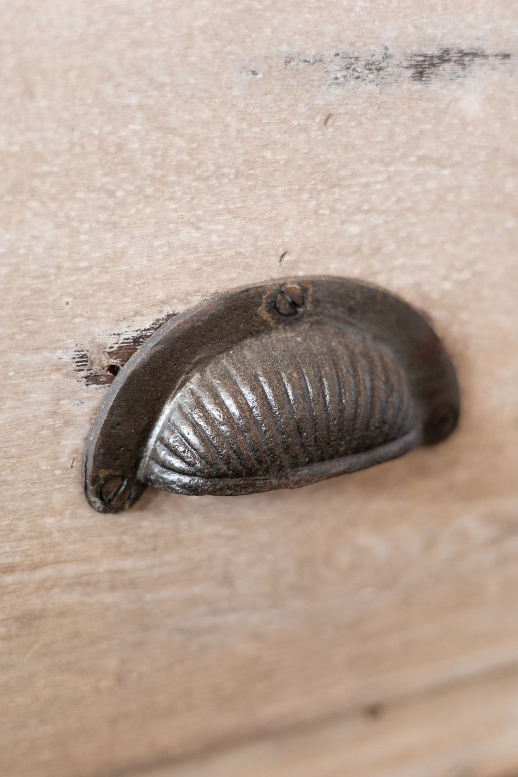 Semi-circular metal handle of Bombay cabinet.