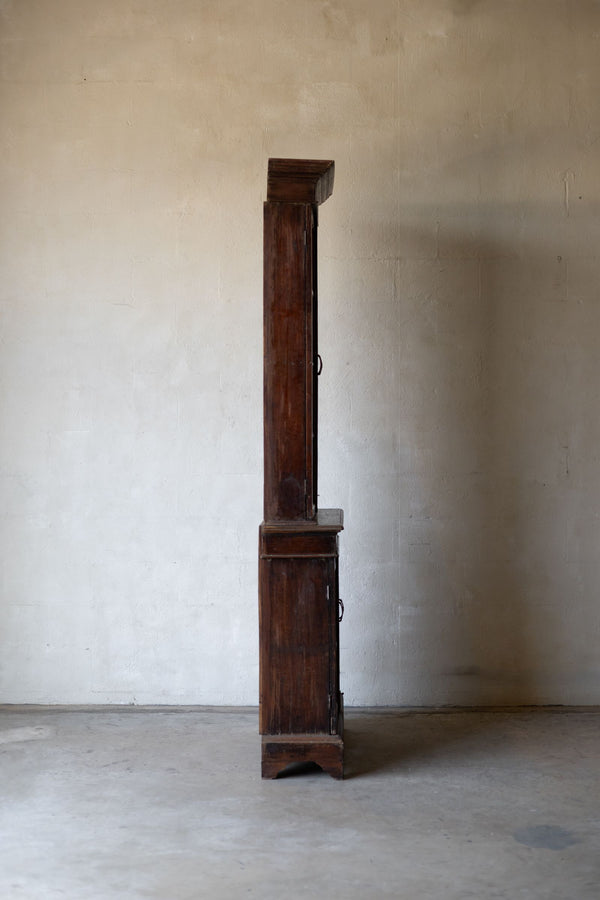 Side profile of wooden bookcase against a plain wall