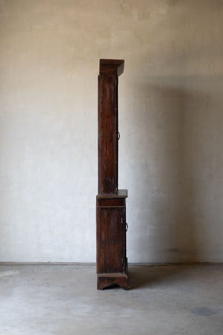 Side profile of wooden bookcase against a plain wall