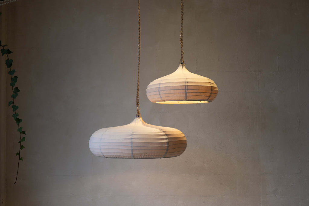 Two teardrop pendant lights with off-white woven canvas and rope and chain cords.