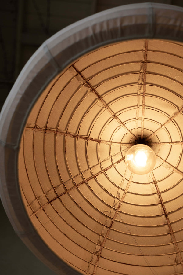 Image showing inside of pendant light's industrial metal frame and warm glow from lightbulb.