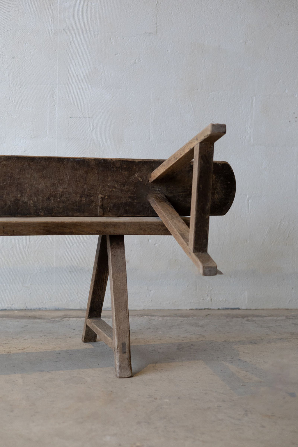 Two wooden dining bench, featuring natural, rustic wood finish with one stacked on the other and the bottom facing forward.
