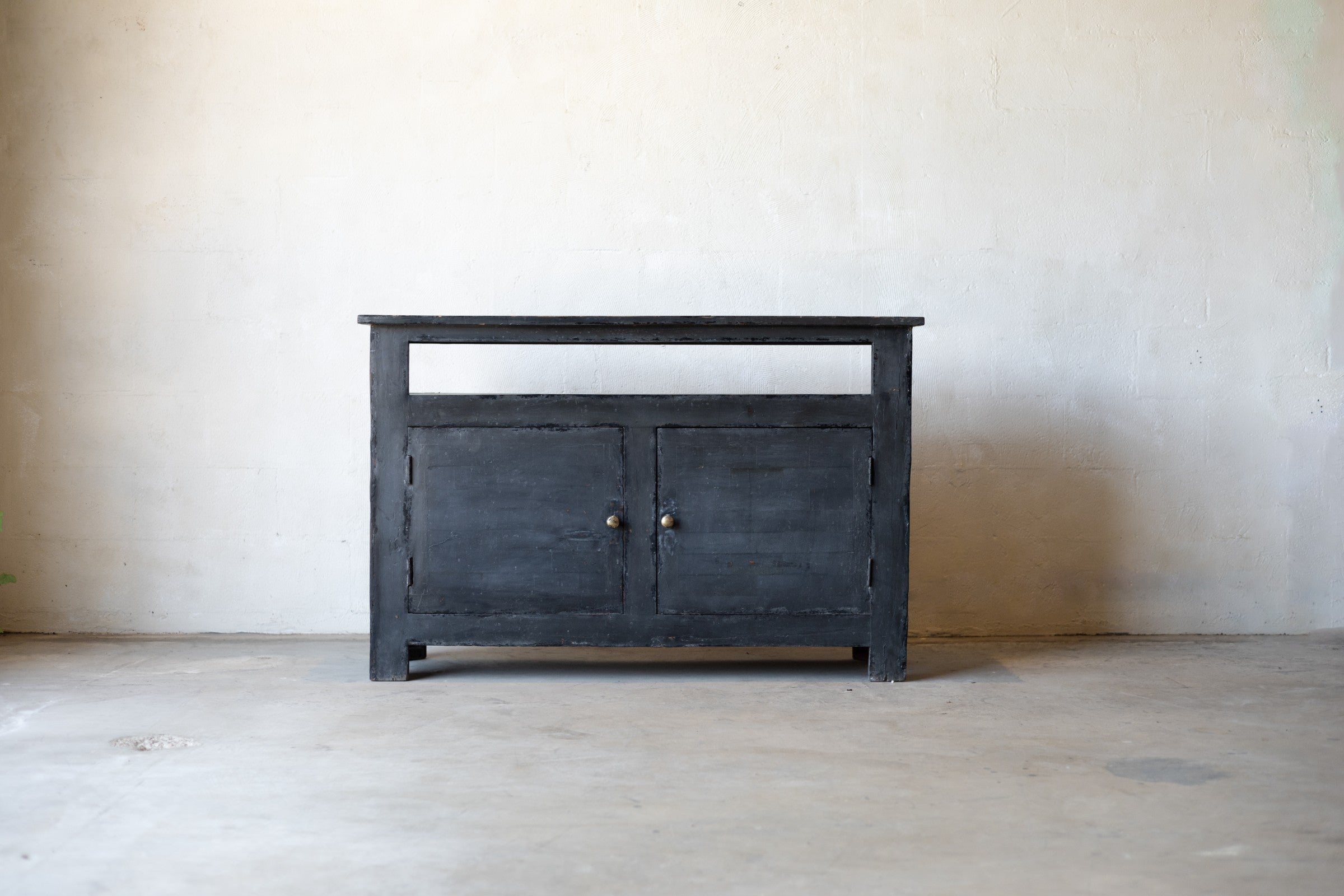 Dark wooden console sideboard against a plain wall.