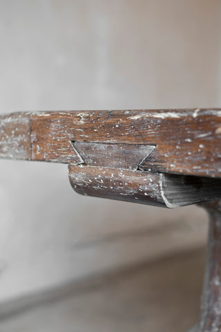 Close-up of a wooden object with a worn surface on a neutral background