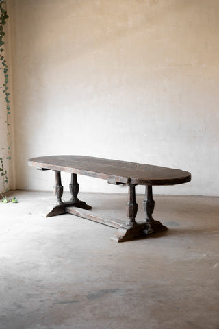 Vintage wooden table in a minimalistic room with a neutral wall and floor.