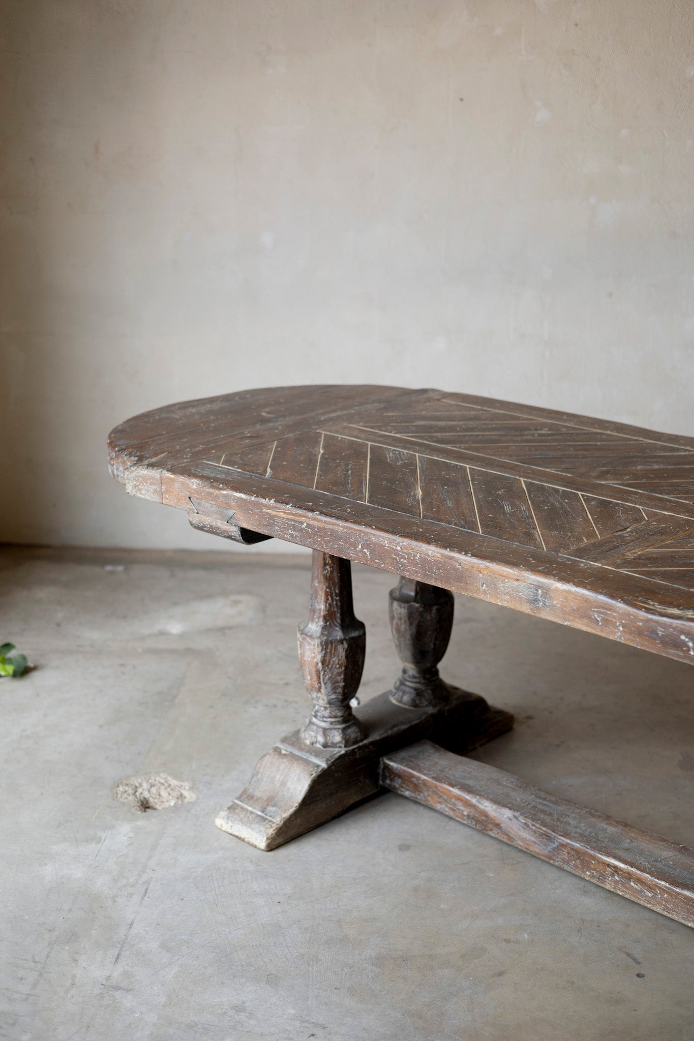 Wooden table with intricate carvings on a plain floor.