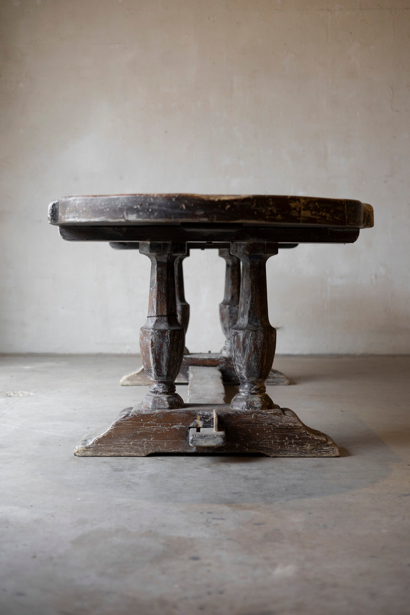 Vintage wooden table with a rustic design on a plain floor and wall background