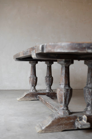 Wooden table with baluster legs against a plain wall