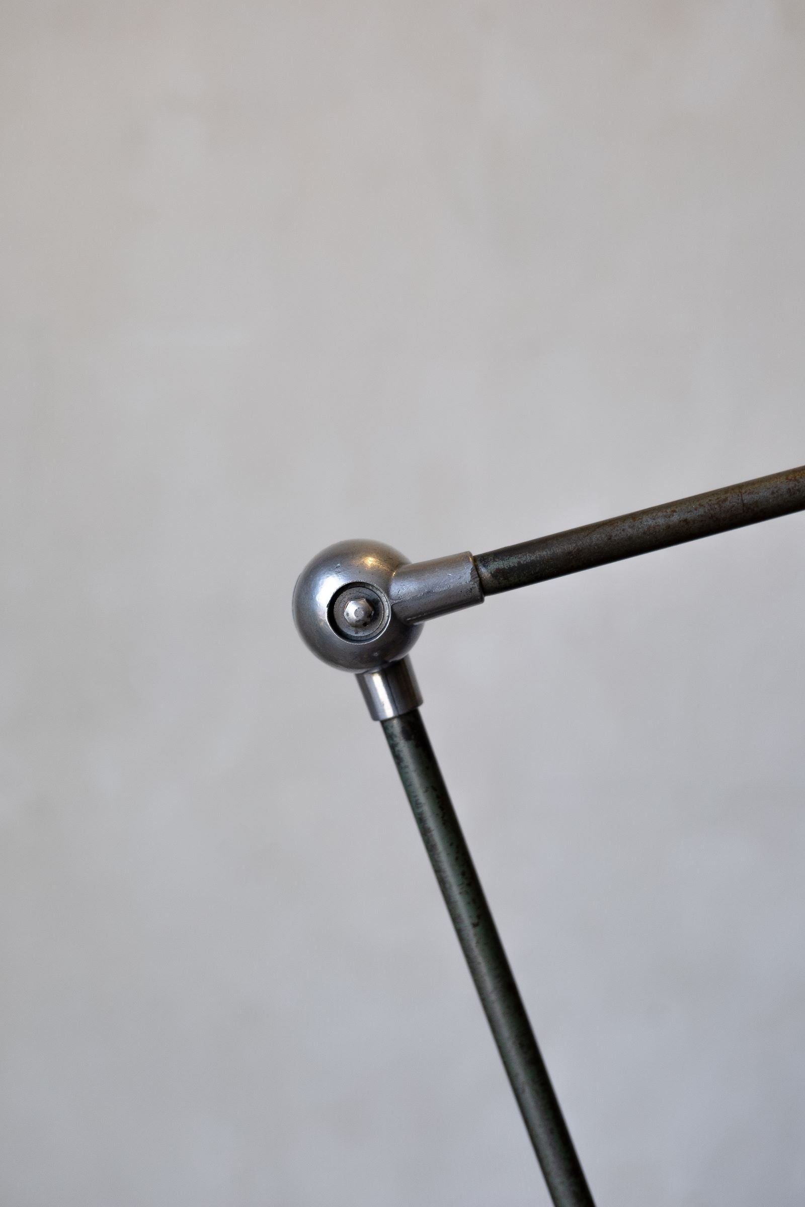 Metal arm with spherical joint on a gray background
