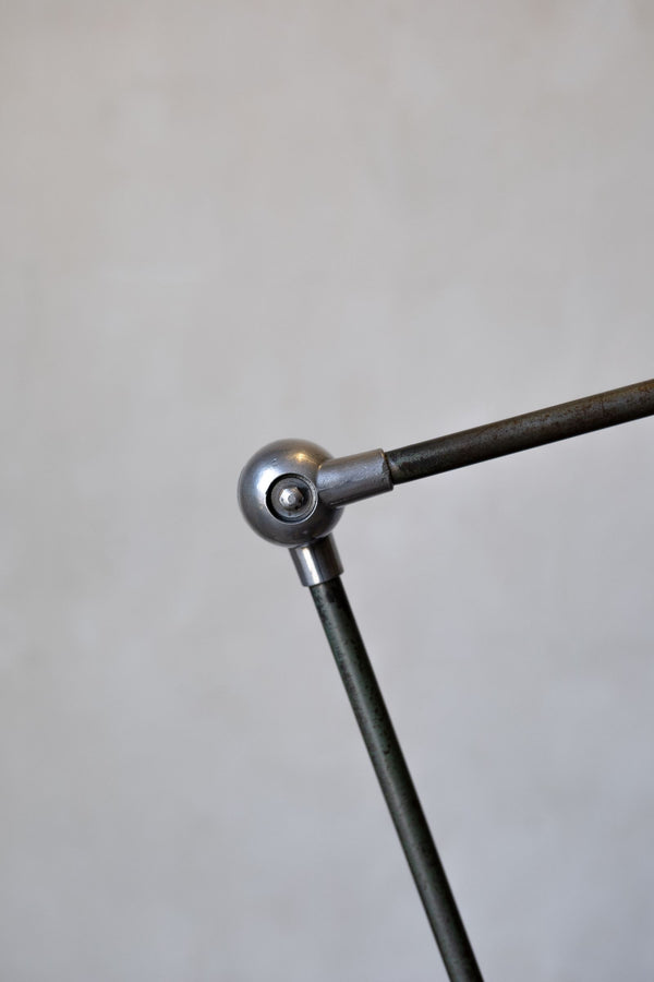 Metal arm with spherical joint on a gray background