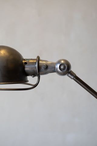 Close-up of a metal Jielde task lamp on a plain background