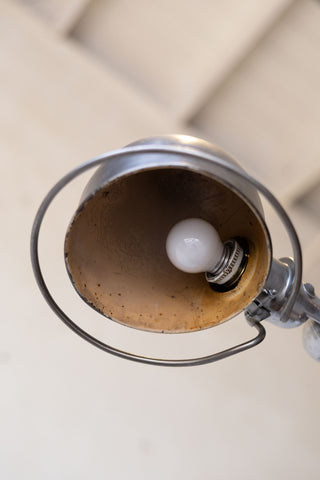 Close-up of a Jielde light bulb inside a lampshade on a neutral background