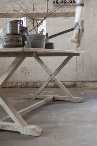 Wooden table with a rustic design in a room with a neutral color palette.