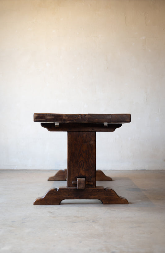 Profile of vintage oak dining table with a rustic design on a light background.