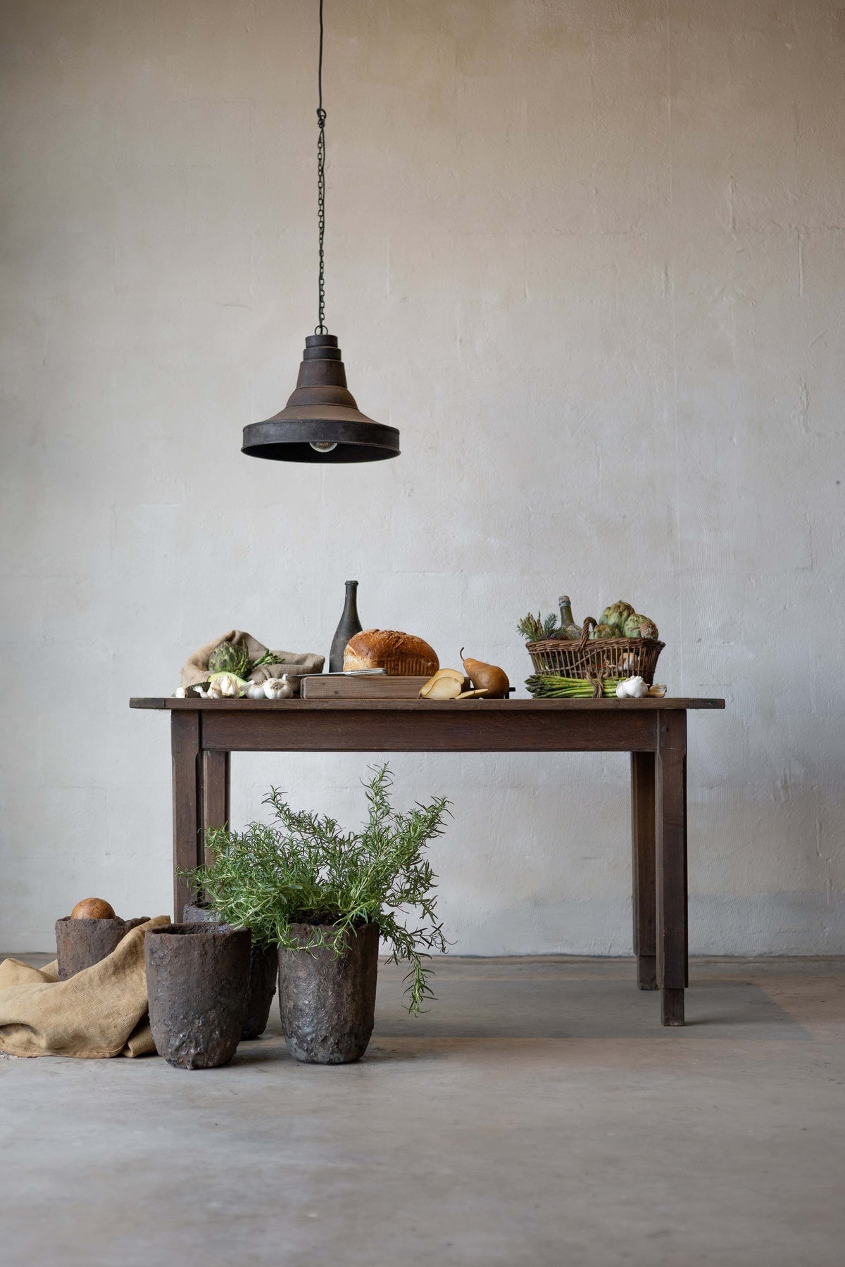 A dark oak table laden with food, an industrial lamp hanging above it. Main image