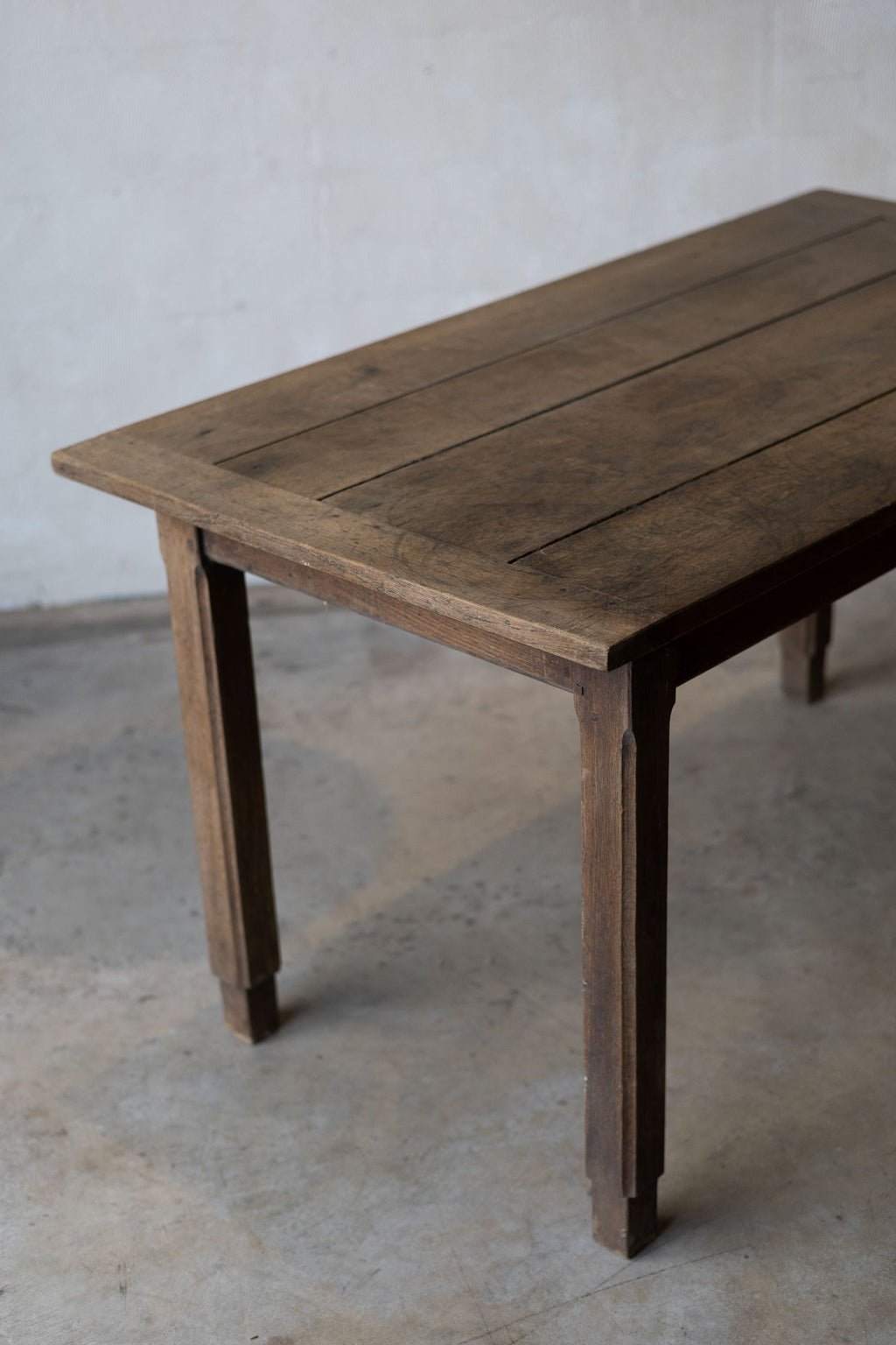 View of the top of an oak farm table with a weathered and rustic finish.