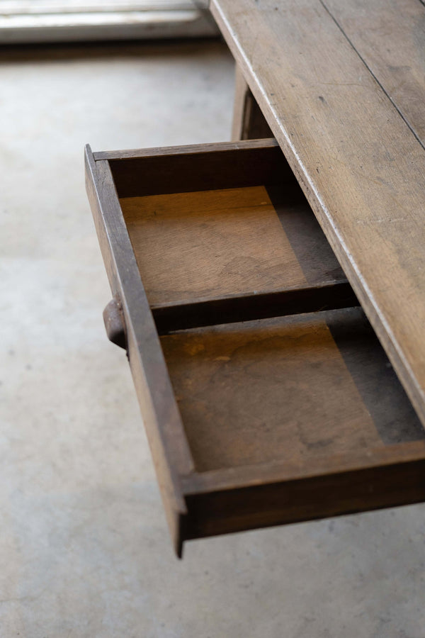 Oak dining table's two-compartment drawer with metal handle.